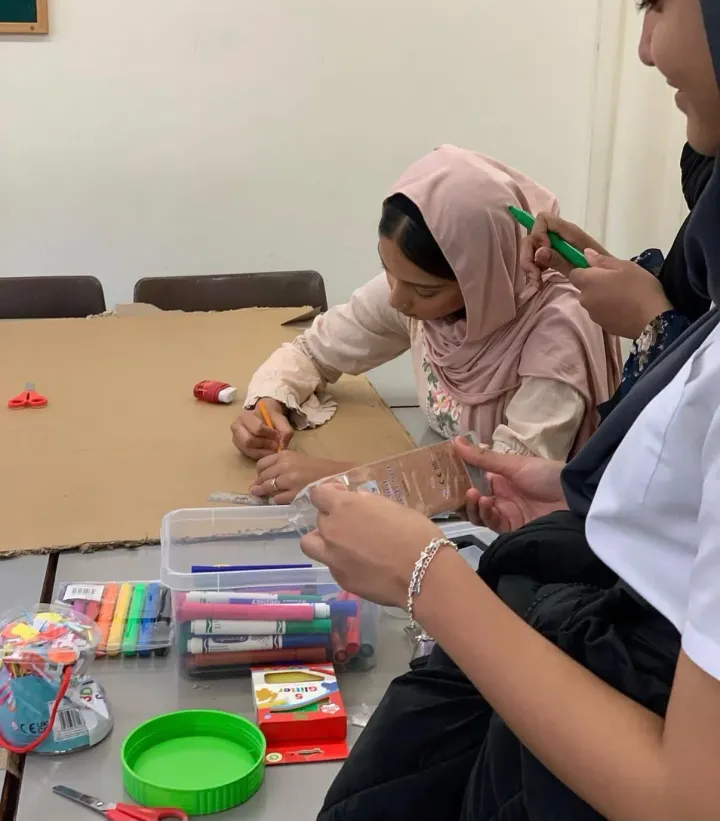 Girls colouring with felt-tip pens at a craft table