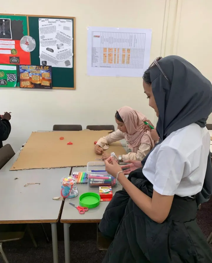 Children working on a cardboard craft project around a table